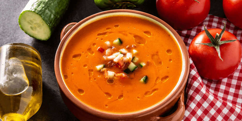 Bowl of dairy-free tomato soup served with toasted bread and herbs