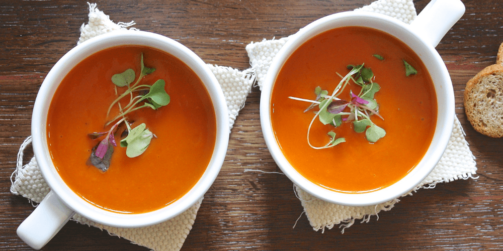 Healthy vegan tomato soup with basil leaves and pepper flakes