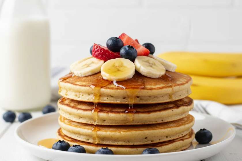 Vegan banana pancakes with fresh fruit and plant-based toppings