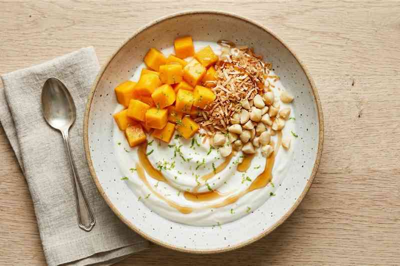 Greek yogurt high protein bowl with mango toasted coconut and macadamia nuts