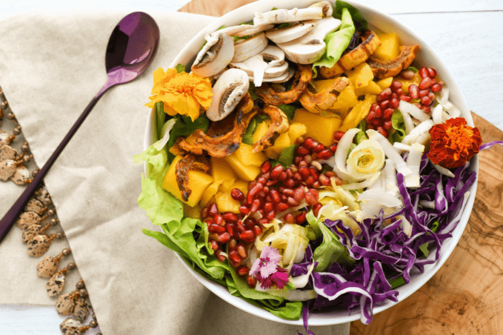 Vibrant Mediterranean vegan salad bowl with roasted pumpkin, mushrooms, pomegranate seeds, cabbage, lettuce, and colorful fresh vegetables