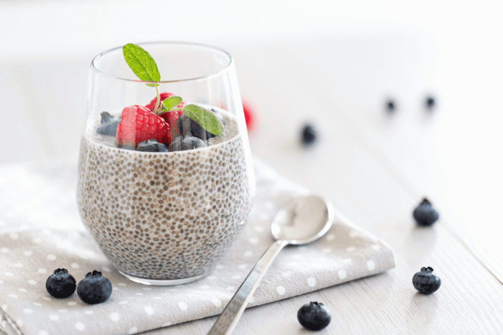 Chia pudding in a glass jar topped with fresh berries and mint – a clean and protein-rich vegan breakfast
