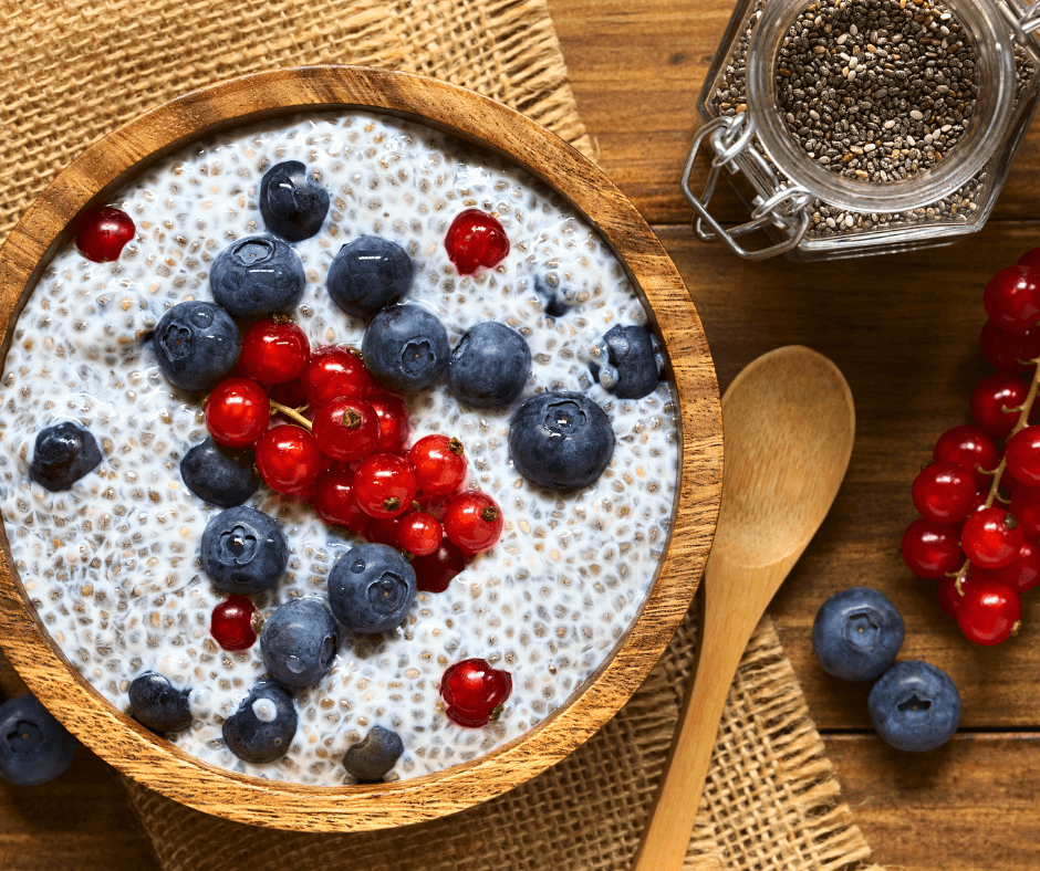 Chia pudding with blueberries and red currants in a wooden bowl – high-protein, omega-3 rich breakfast option.