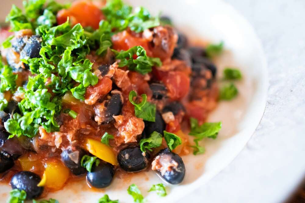 Black beans salad with tomatoes and fresh greens, high protein plant based meal