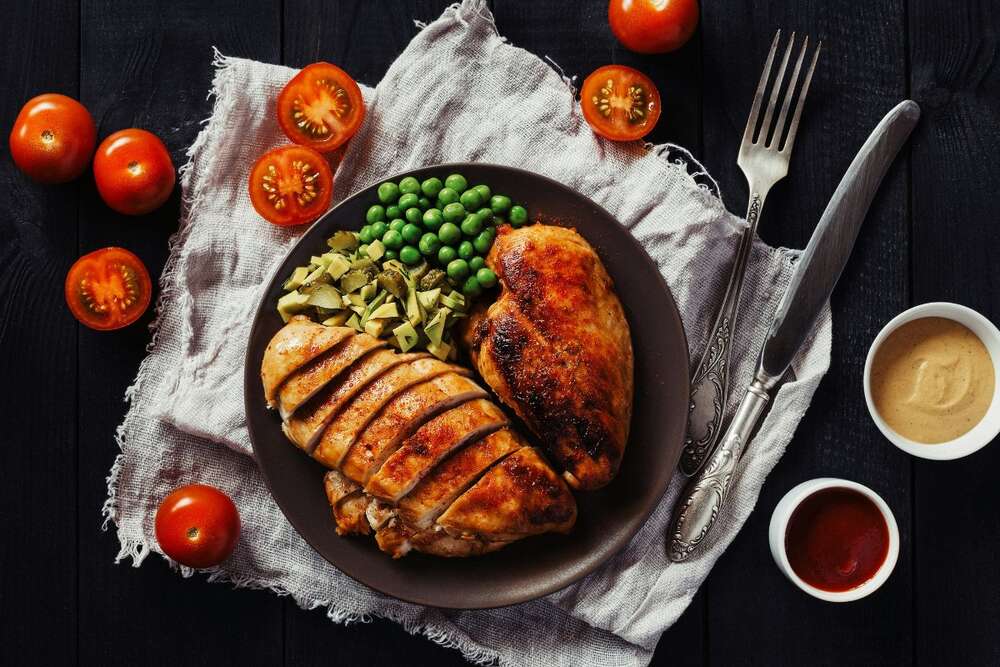 Grilled chicken breast with green peas and tomatoes, high protein food