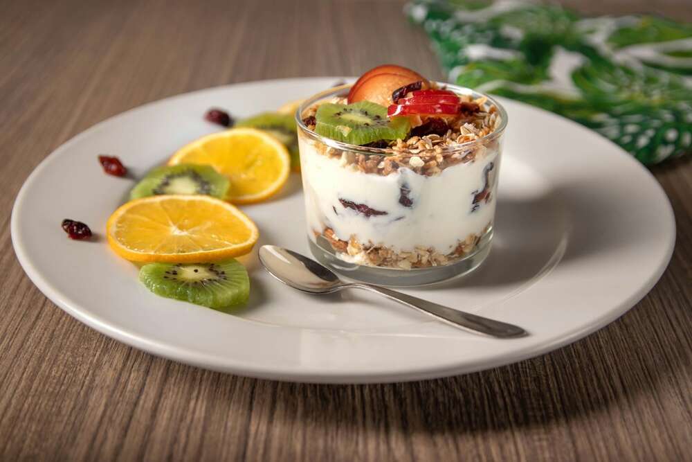 Greek yogurt parfait with granola, kiwi and orange slices, high protein breakfast