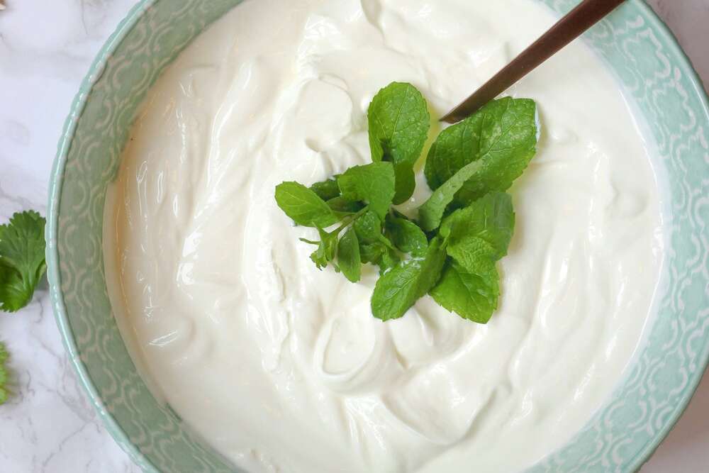 Creamy cottage cheese in a bowl with fresh herbs, high protein food