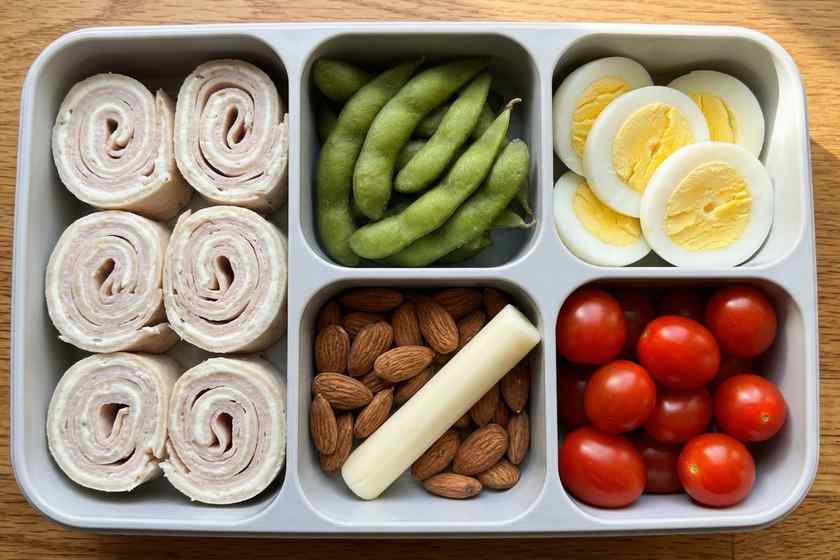 Turkey roll-up bento box with edamame, eggs, and almonds for no cook high protein lunch meal prep