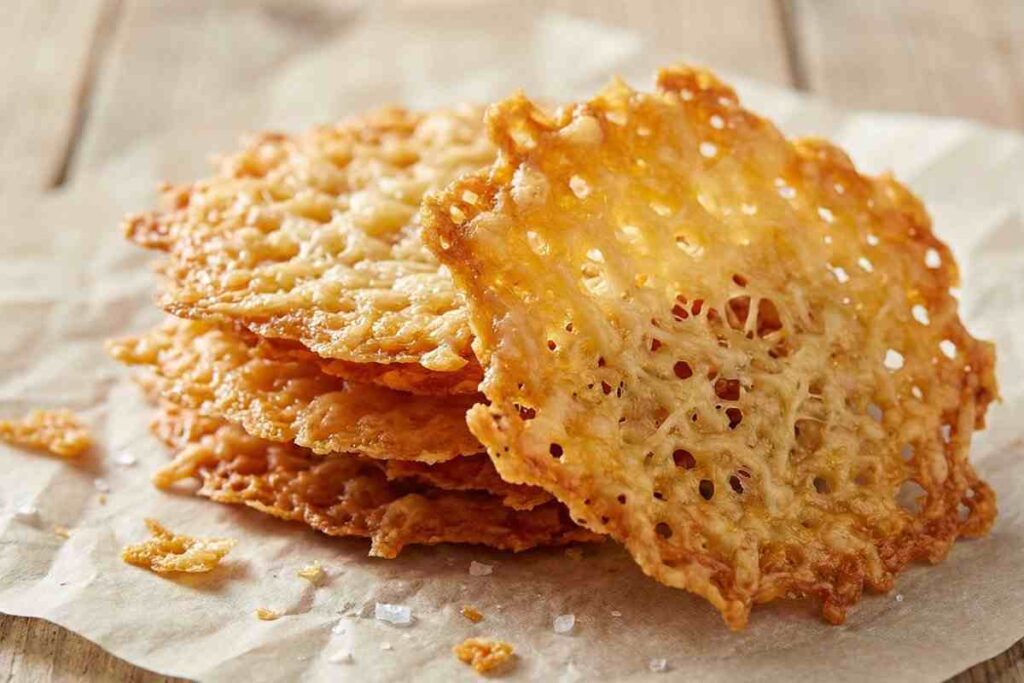 Homemade crispy cheese crisps made with cheddar and parmesan on parchment paper - keto-friendly high protein snack with 14g protein