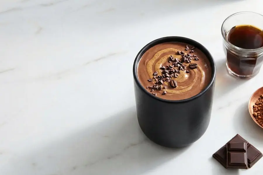 Chocolate focus smoothie with cacao and coffee beans in black ceramic cup
